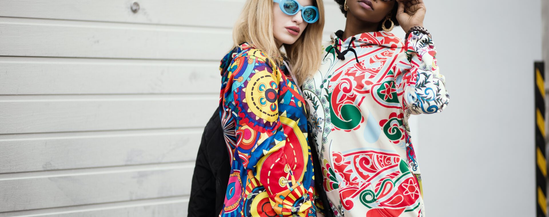 Dwie młode kobiety w kolorowych modnych bluzach, stojąca na ulicy