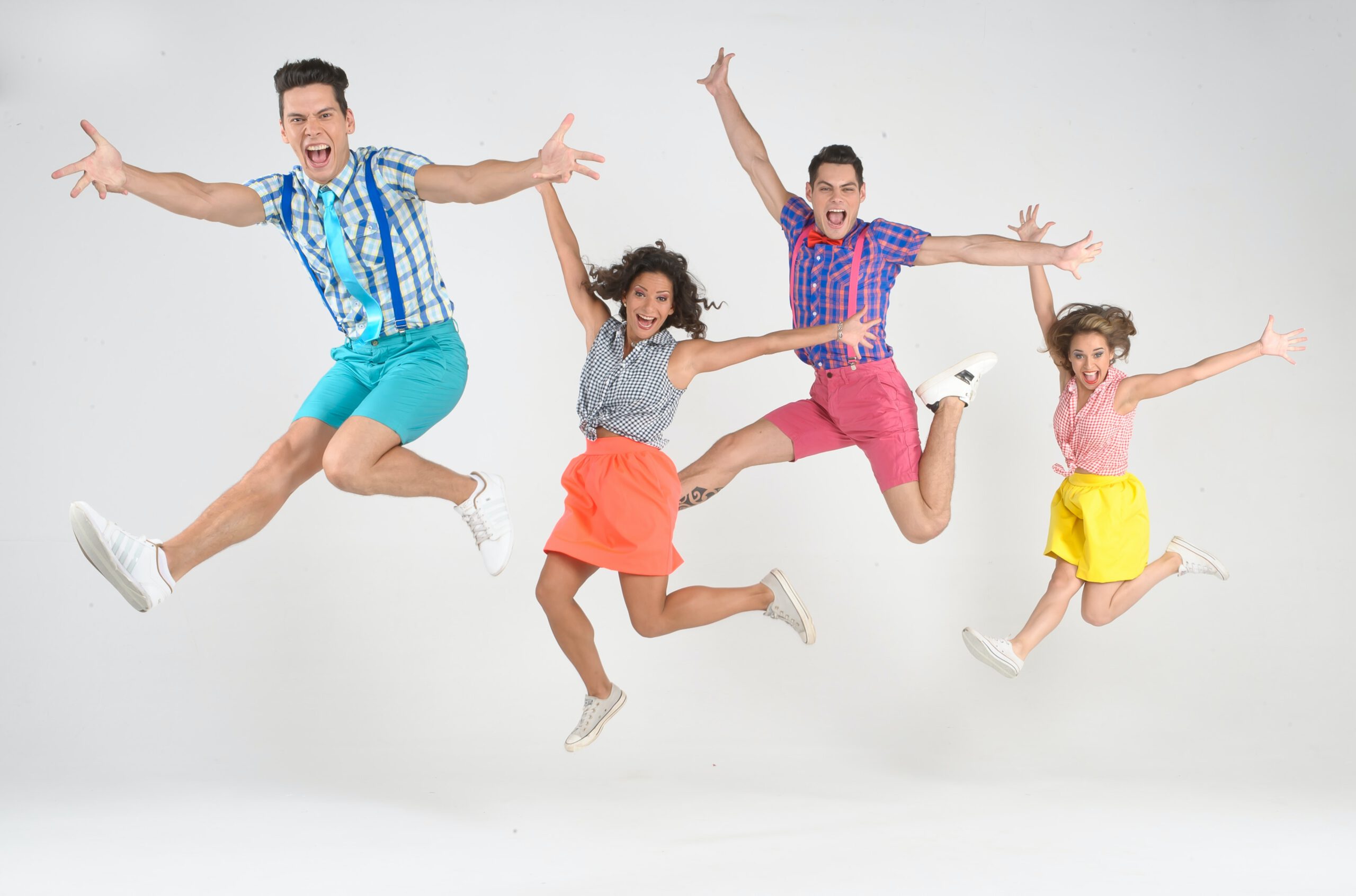 Młodzi ludzie ubrani w kolorowe ubrania skaczący na białym tle