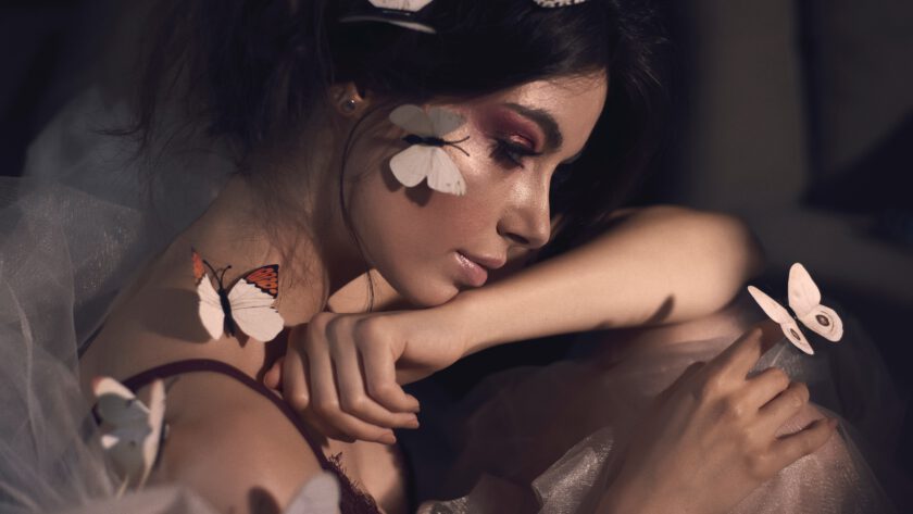 Portret kobiety z pięknym makijażem i przyczepionymi motylkami w wersji 3D